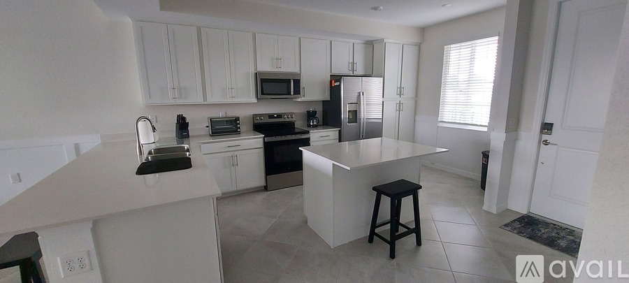 A kitchen with white cabinets and a central island.