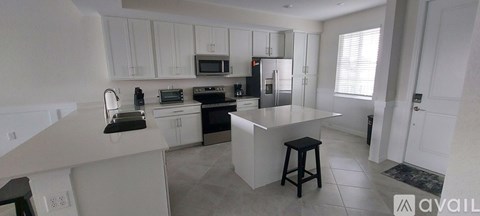 A kitchen with white cabinets and a central island.