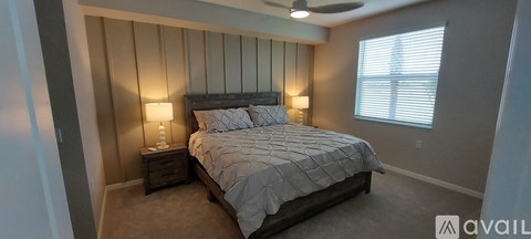 A bedroom with a large bed and a ceiling fan.