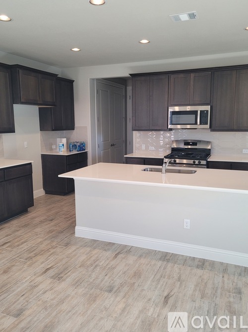 A kitchen with dark brown cabinets and a white island.