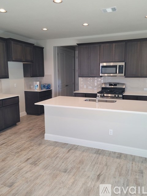 A kitchen with dark brown cabinets and a white island.