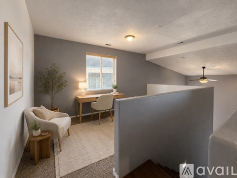 A living room with a couch, chair, and a small table with a plant on it.