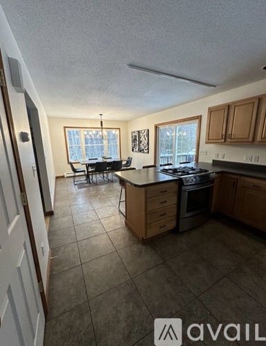 A kitchen with tile flooring and wooden cabinets.