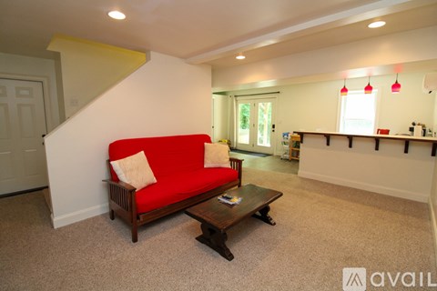 A living room with a red couch and a coffee table.