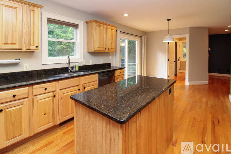A kitchen with wooden cabinets and a granite countertop.