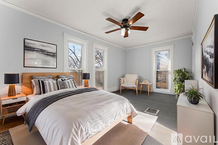 A bedroom with a large bed and a ceiling fan.