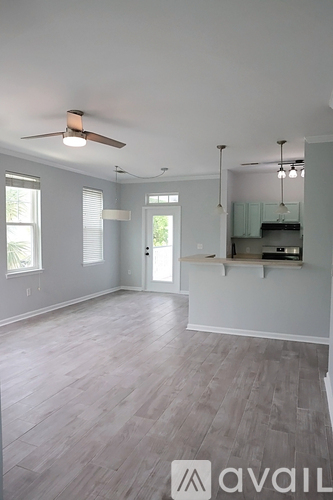 A spacious room with a ceiling fan and lighting fixtures.