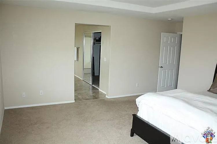 A bedroom with a bed, dresser, and mirror.