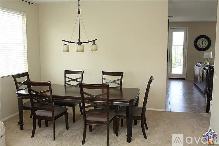 A dining room with a table and chairs.