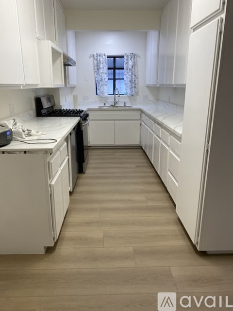 A kitchen with white cabinets and a black dishwasher.