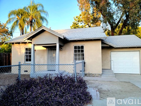 A house with a fence and a garage door.