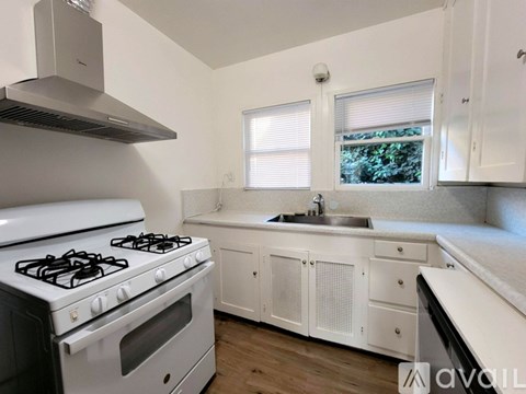 A modern kitchen with a white stove and cabinets.