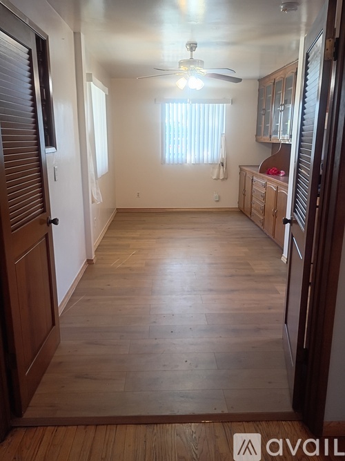 A room with wooden floors and a ceiling fan.