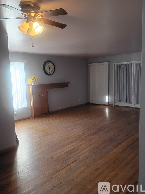 A room with wooden floors and a ceiling fan.