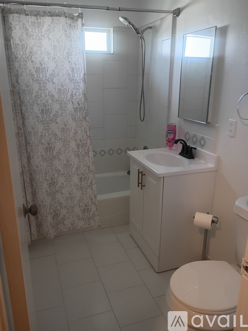 A bathroom with a toilet, sink, and shower.