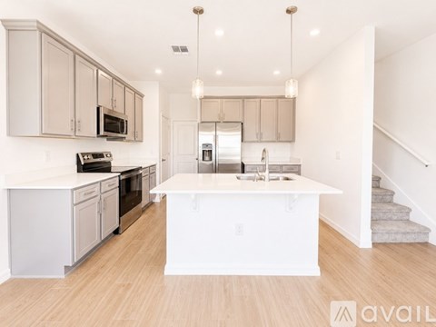 A modern kitchen with a center island and stainless steel appliances.