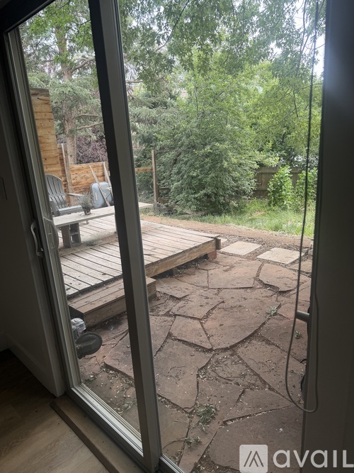 A patio with a table and chairs is visible through a glass door.