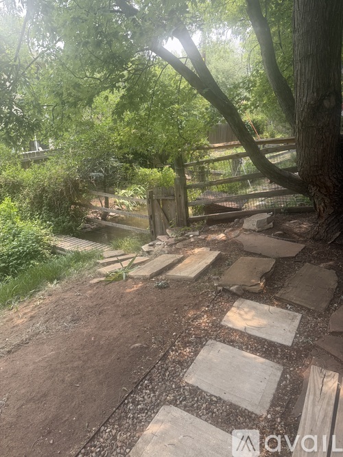 A pathway made of stepping stones leads through a lush green garden.