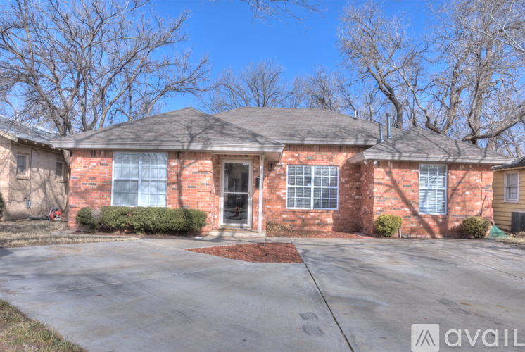 A brick house with a driveway in front.