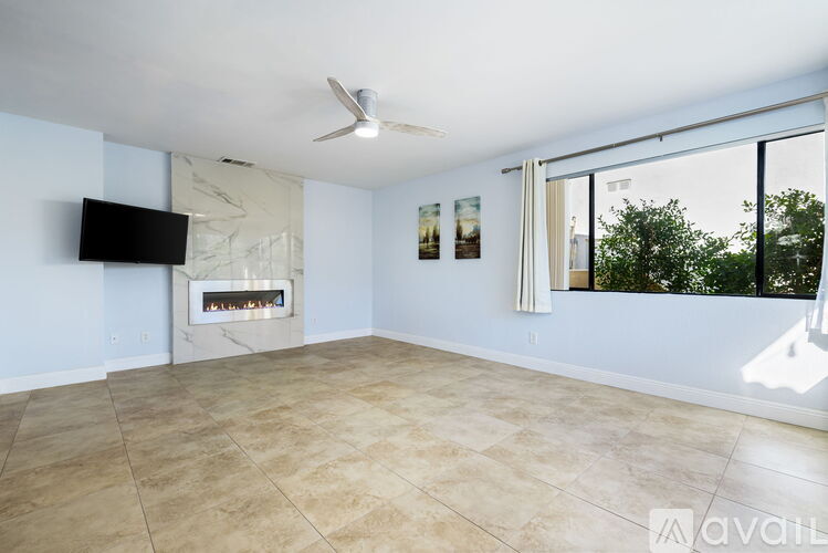 A living room with a fireplace and a flat screen TV mounted on the wall.
