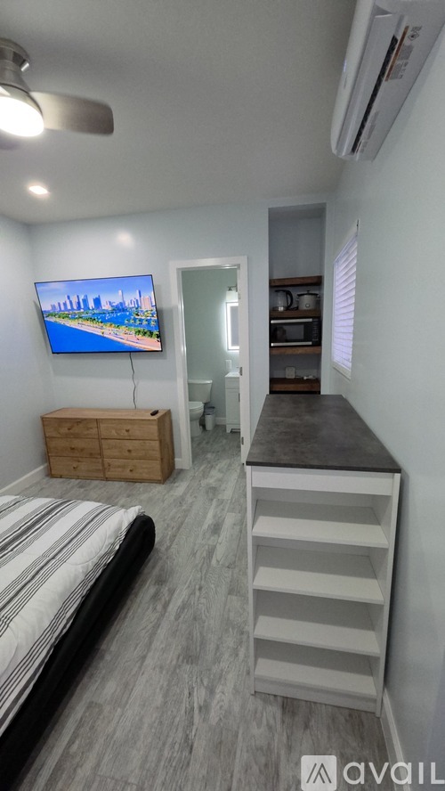 A bedroom with a bed, a TV, and a wooden cabinet.