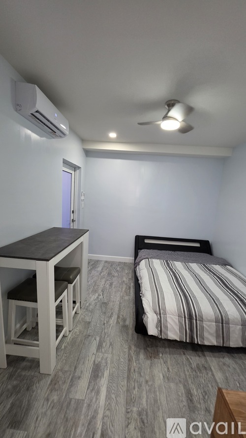 A bedroom with a bed, desk, and chair.
