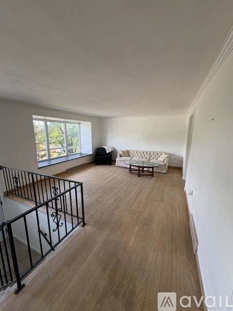 A living room with a white couch and a black metal railing.