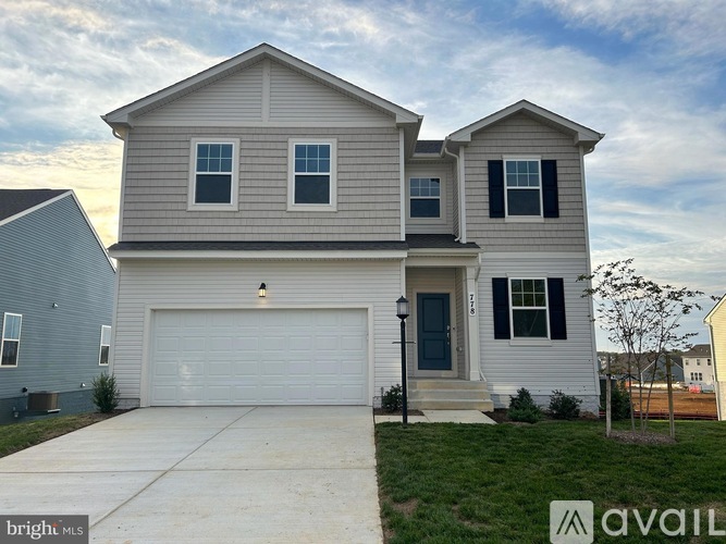 A two-story house with a garage is available for sale.