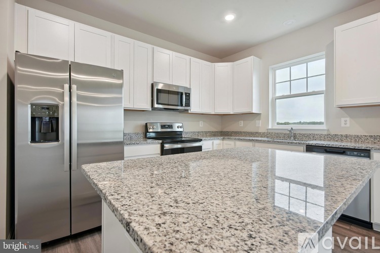 A kitchen with granite countertops and stainless steel appliances.