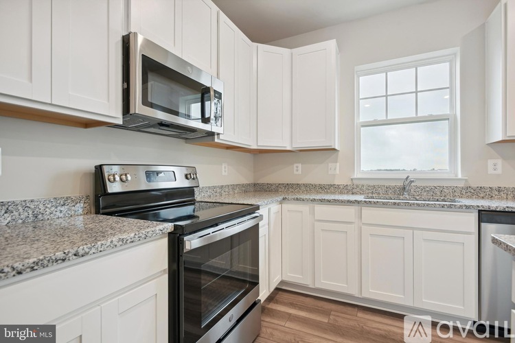 A kitchen with white cabinets and a granite countertop.