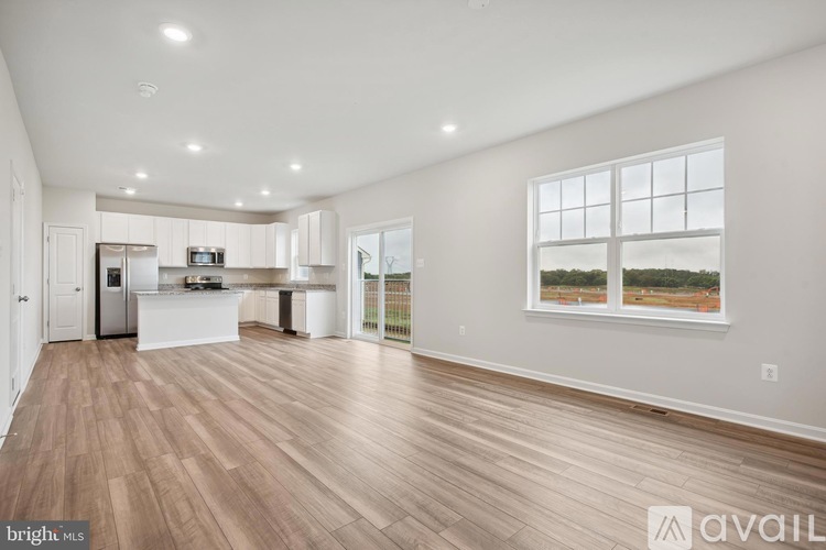 A spacious living room with hardwood floors and a large window.