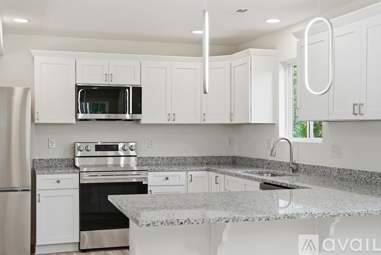A kitchen with white cabinets and a granite countertop.