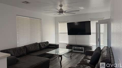 A modern living room with a black leather sofa and a glass coffee table.