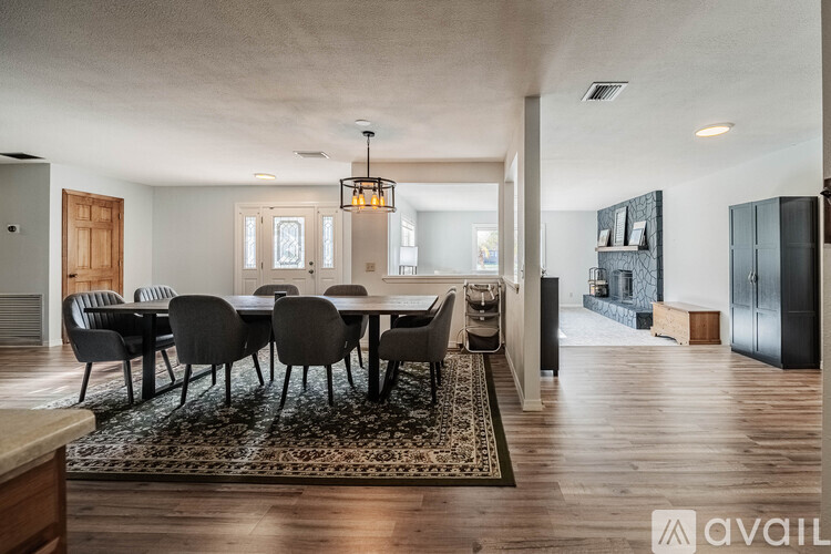 A dining room with a large table and chairs.