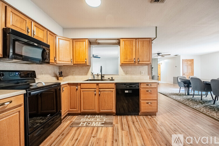 A kitchen with wooden cabinets and black appliances.