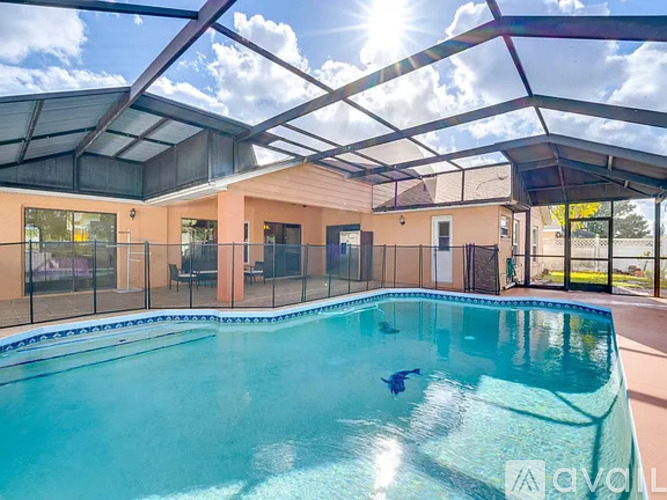 A person is swimming in a pool under a sunny sky.