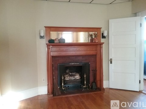 A fireplace with a white door in the background.