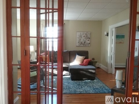 A bedroom with a bed and a blue rug.
