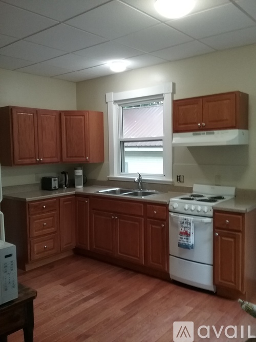 A kitchen with wooden cabinets and a white stove.