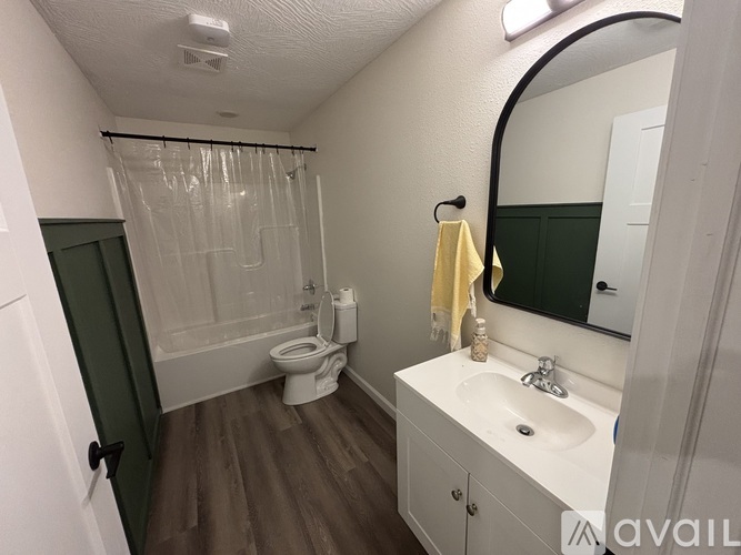 A bathroom with a toilet, sink, and shower.