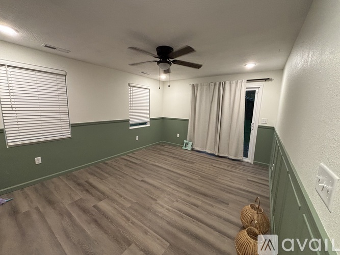A room with a ceiling fan and wooden flooring.