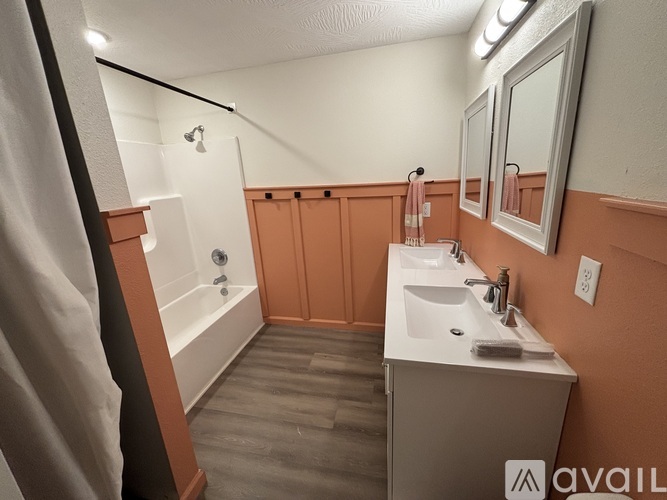 A bathroom with a white tub, sink, and mirror.