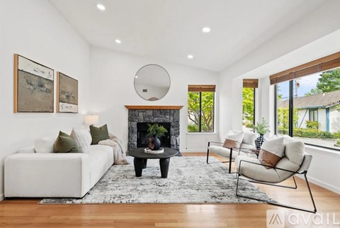 A modern living room with a fireplace and a large mirror on the wall.