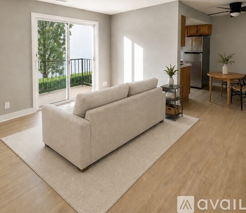 A living room with a white couch and a ceiling fan.