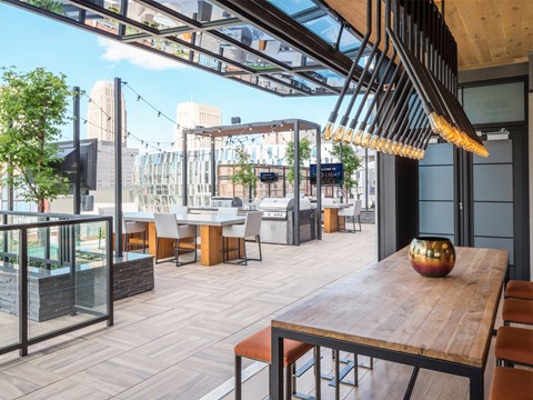 A modern outdoor dining area with wooden tables and chairs.
