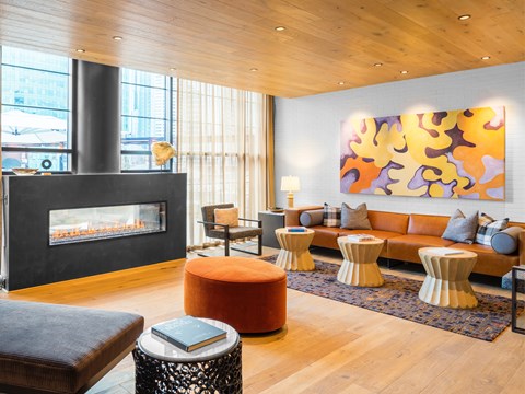 A living room with a fireplace and a large painting on the wall.