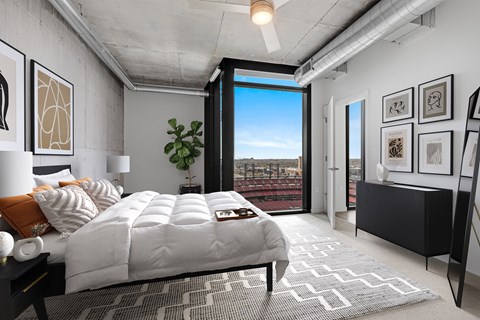A bedroom with a large bed and a view of the city.