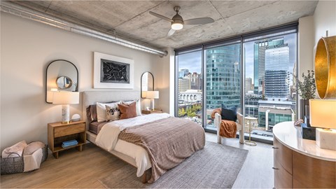 A bedroom with a large bed and a view of the city.