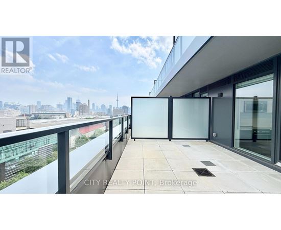 A balcony with glass railings overlooking a cityscape.