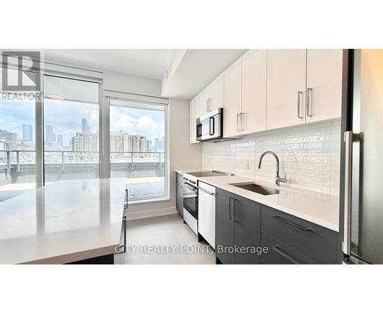 A modern kitchen with a view of the cityscape outside the window.